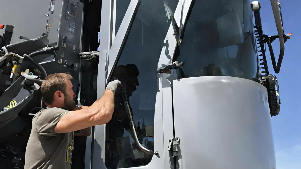 Technician installing farm equipment glass for a Canora area customer